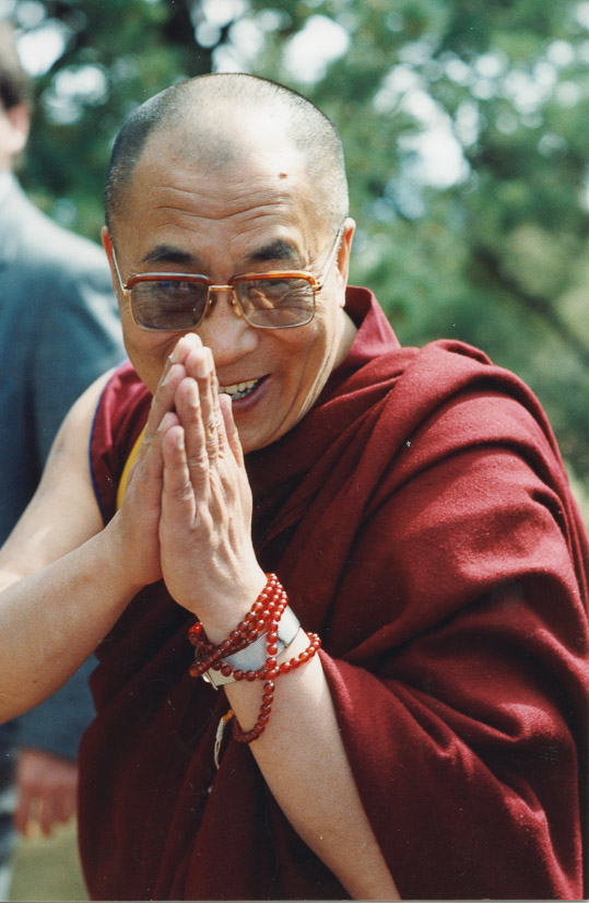 Photograph of His Holiness the 14th Dalai Lama with hands in a prayer mudra; date and location unknown.