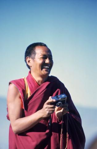 Lama Yeshe holding a camera and laughing, at Kopan Monastery, Kathmandu, Nepal, 1980.
