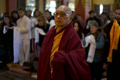 Lama Zopa Rinpoche looks up at the large buddha statue in the Chenrezig Gompa at Kopan Monastery, Nepal, November 2019. Photo: Bill Kane.